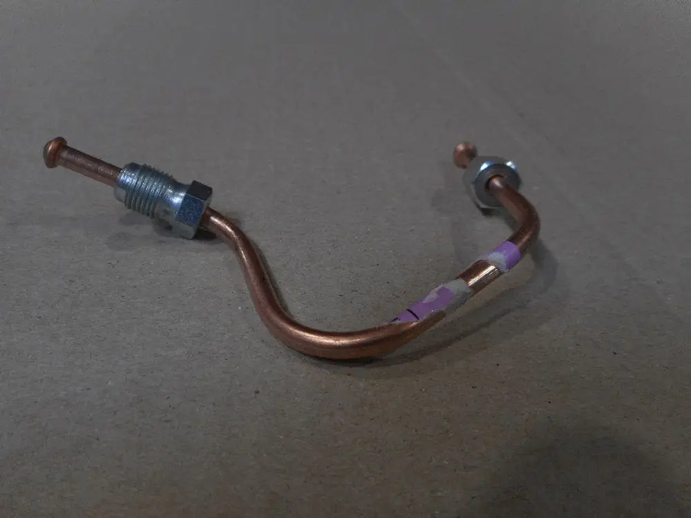Remeha Druckleitung mit gewundenem Kupferrohr und Anschlussstücken, geeignet für Pumpeninstallationen.
